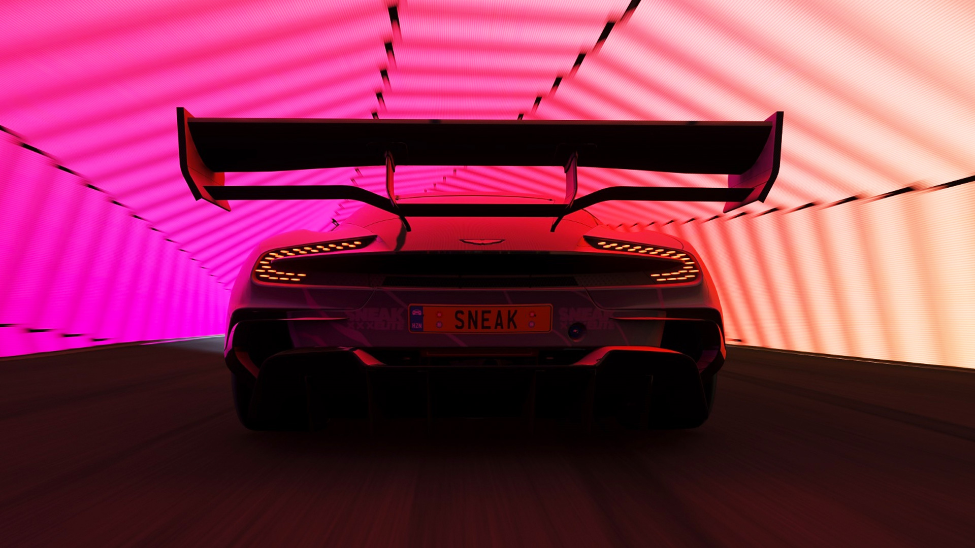 The back of an Aston Martin featuring a livery we created for Sneak energy. The license plate says SNEAK